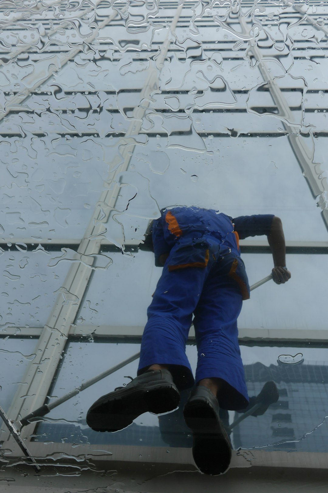 team-02 window-cleaner-working-on-a-glass-building-exterior-s6lojzu69s4